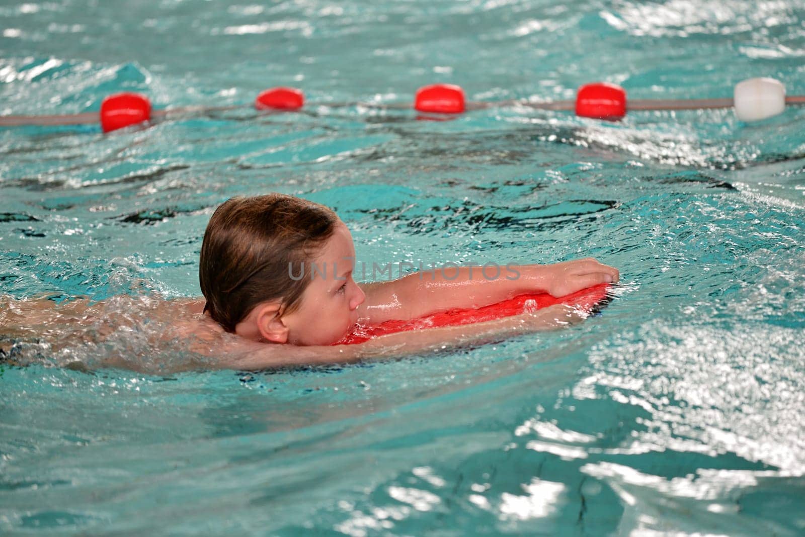 boy swimming with swimming board