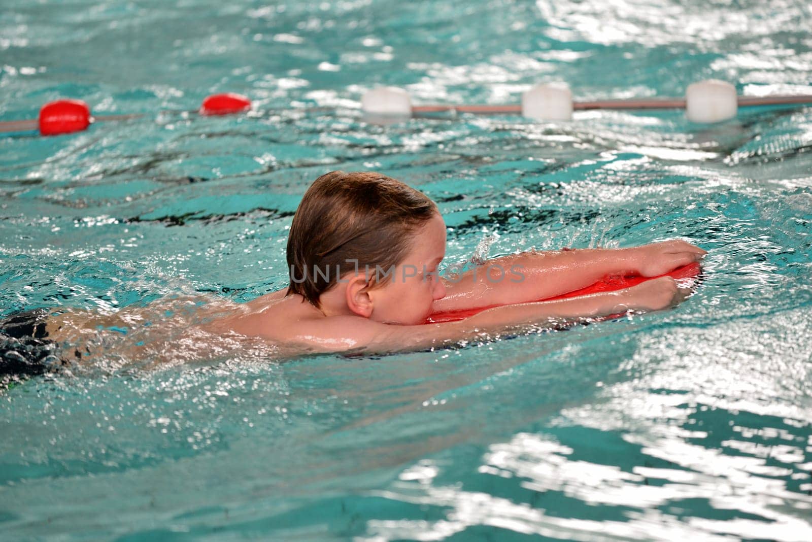 boy swimming with swimming board