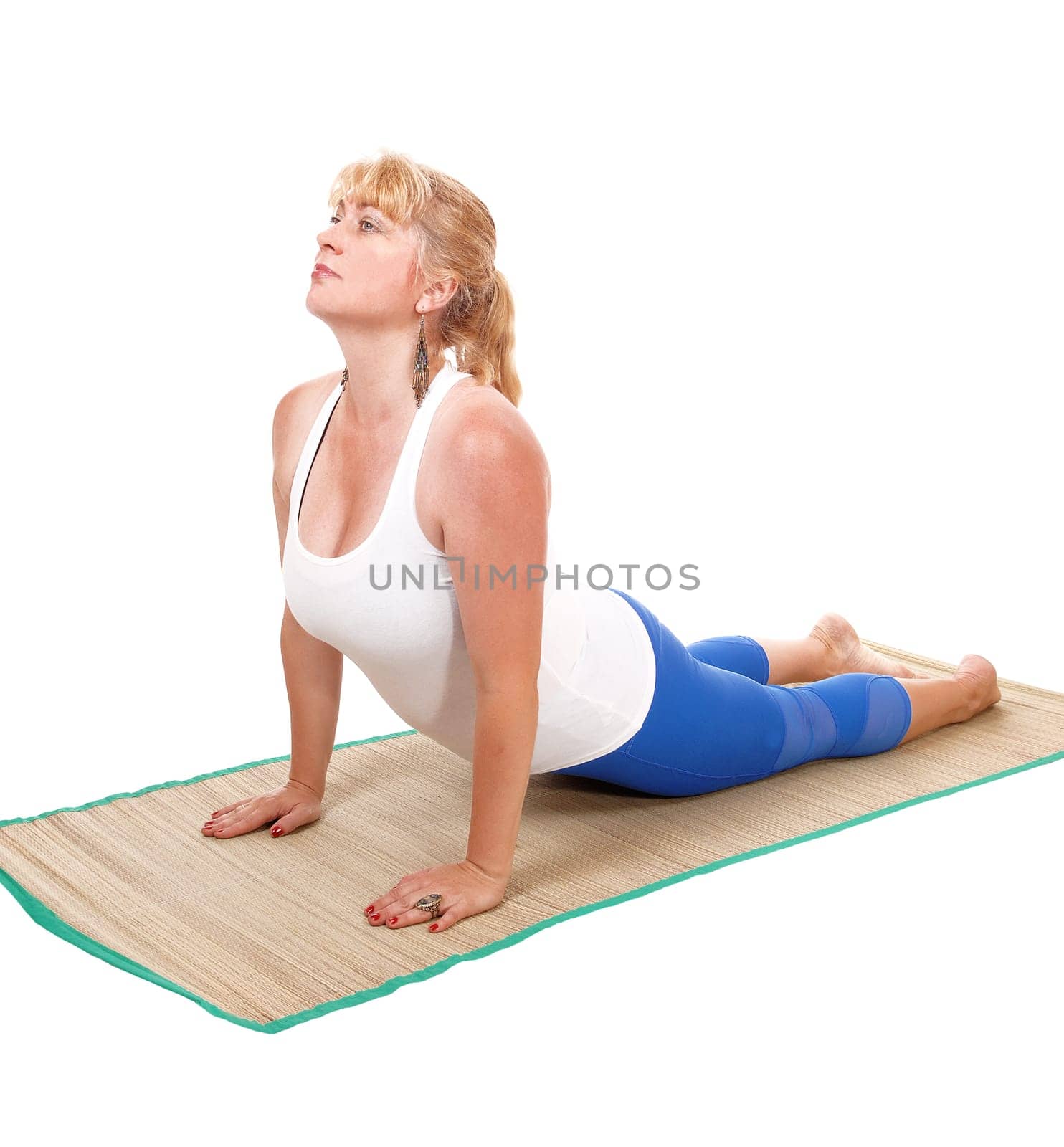 A lovely blond woman is yoga outfit lying on her stomach showing some .yoga exercises, isolated for white background..