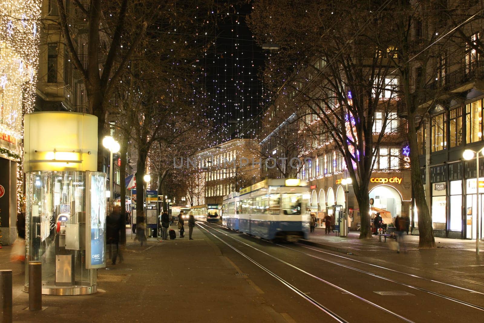Zurich, Switzerland - November 28, 2011. Evening view of the street before Christmas. Tram rushes through the evening streets.