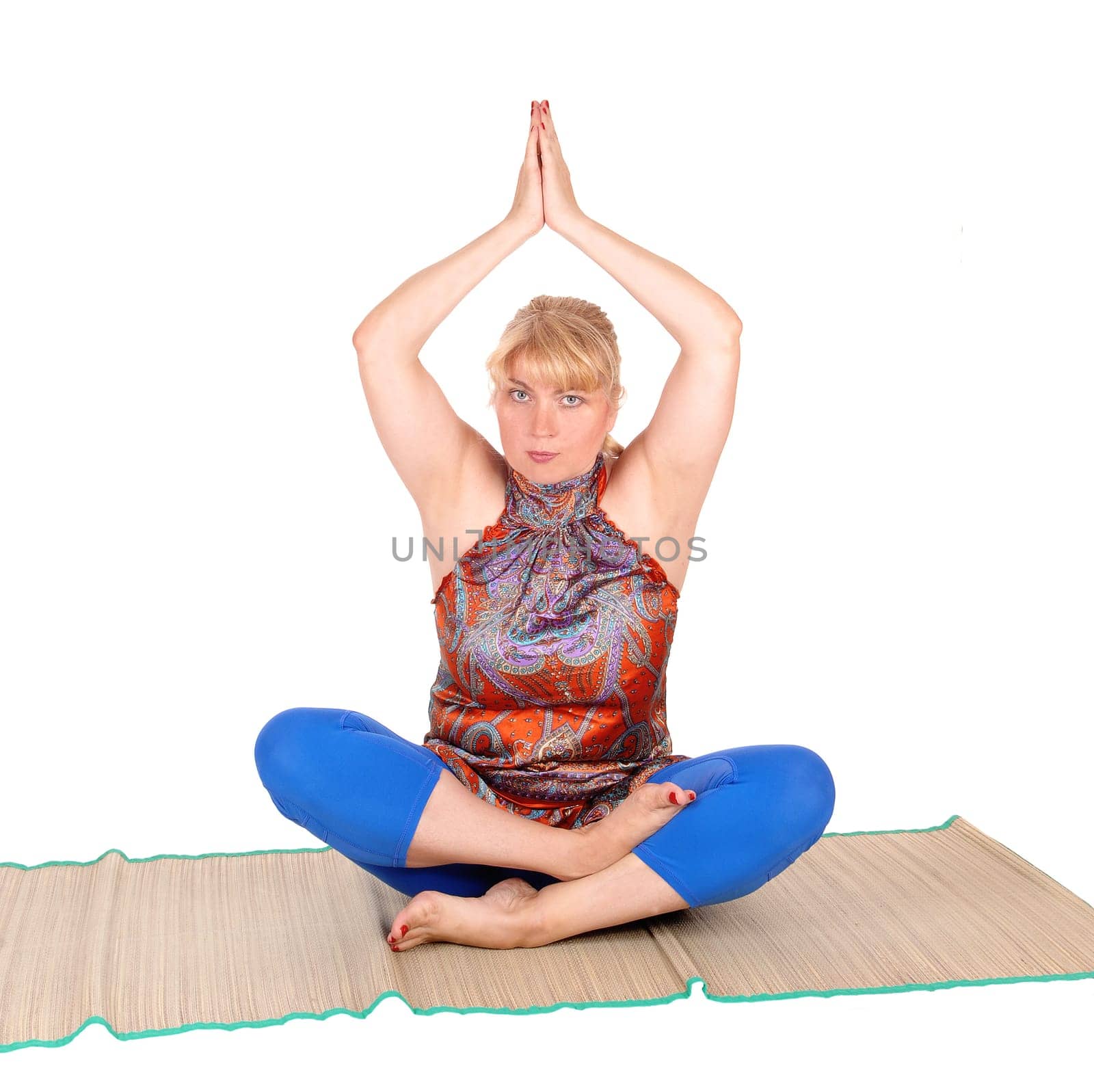 A beautiful blond woman sitting on the floor showing some nice yoga.poses, in a blue pants, isolated for white background..