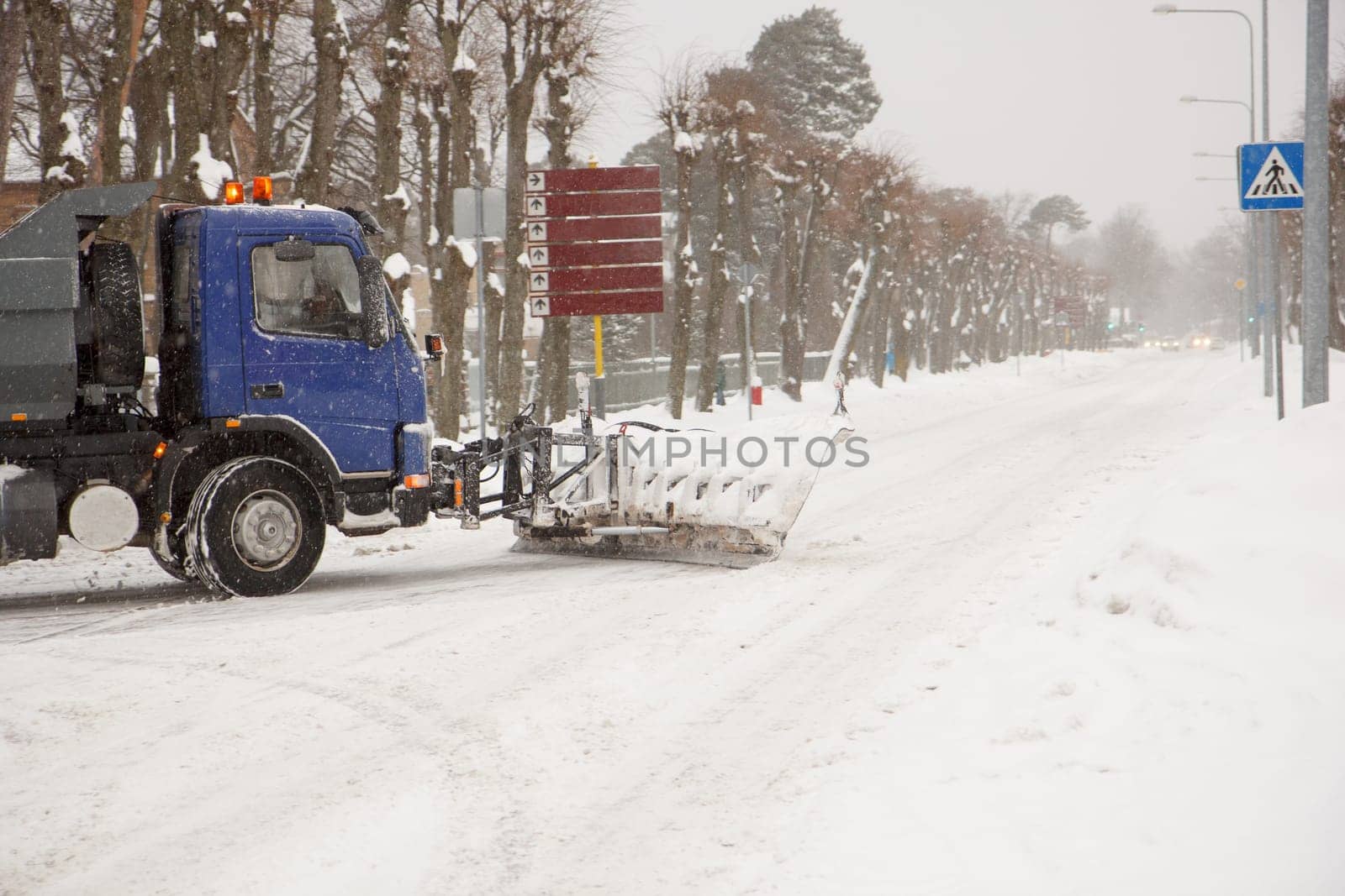 A truck cleaning snow off of the road