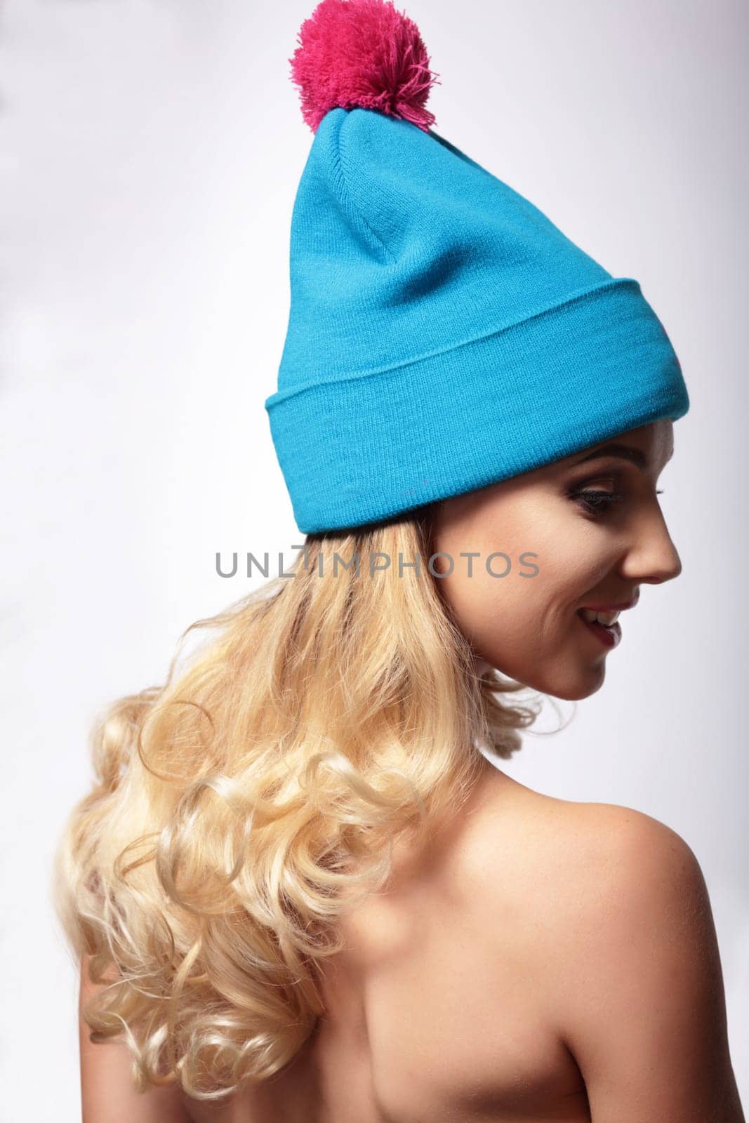 A woman in a knitted hat, stands back and looks down.
