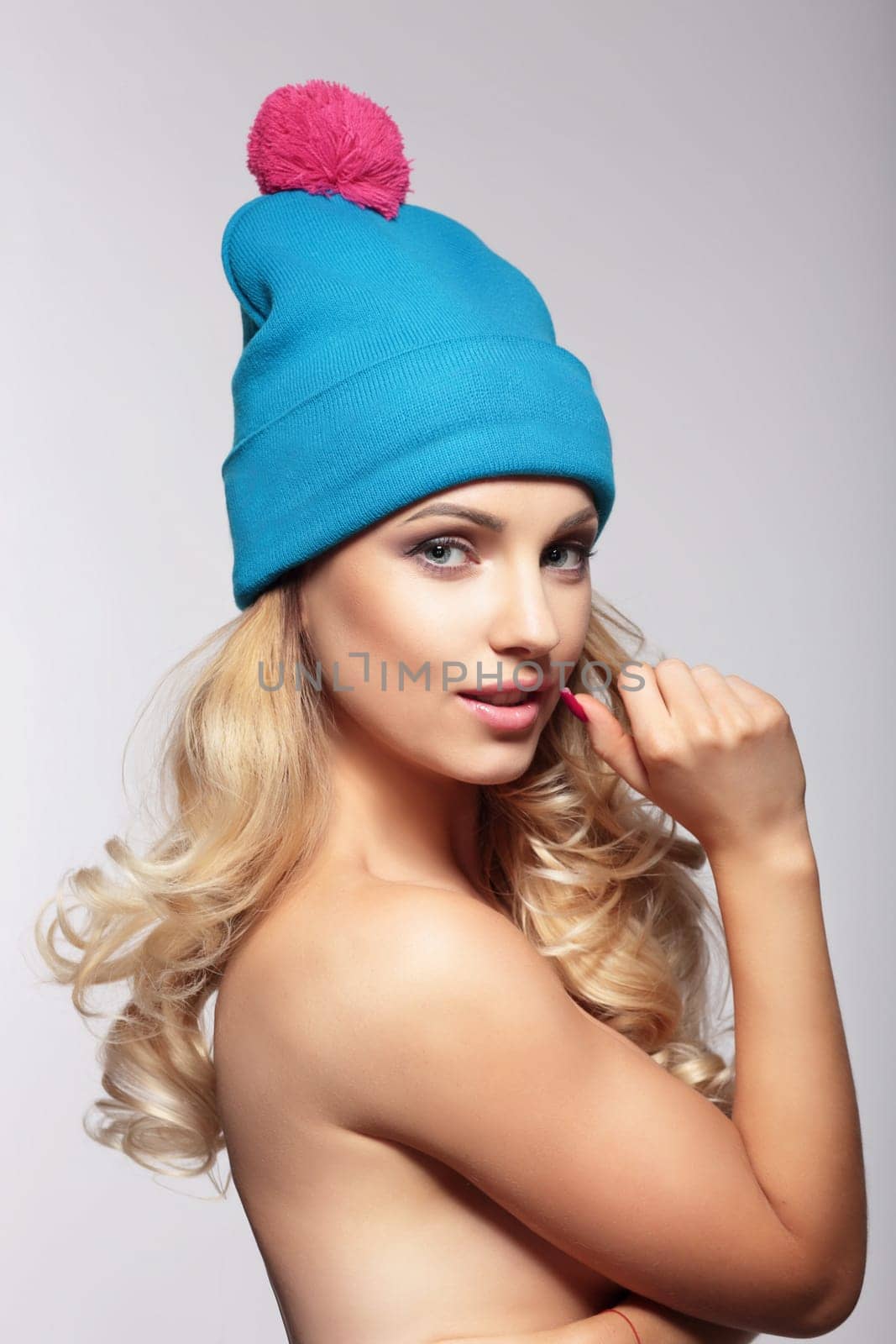 Portrait of beautiful blond woman in blue wool hat.