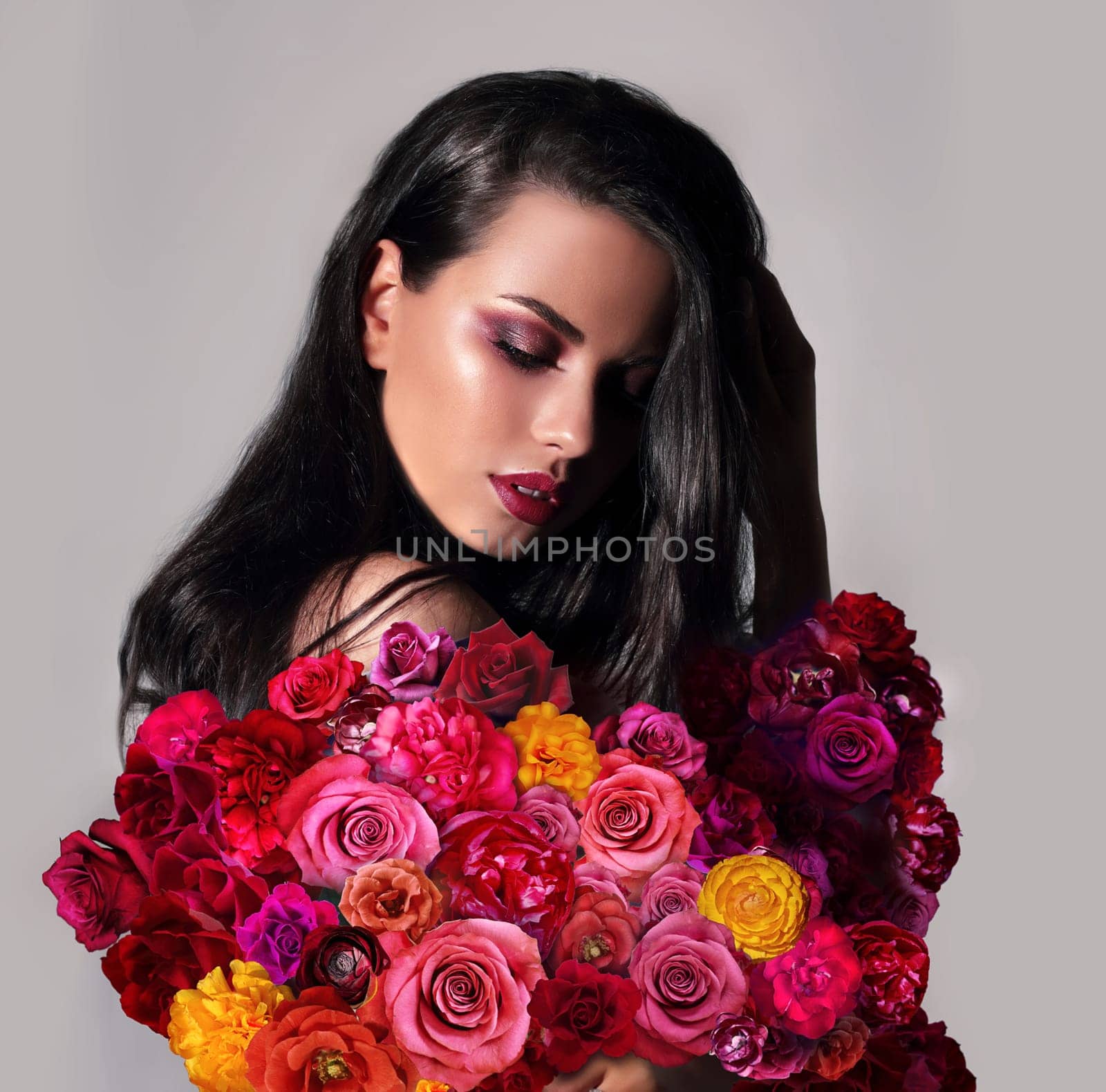Fashion Beauty Model Girl with Flowers. Bouquet of Beautiful Flowers. The dress of flowers. Bright color. Professional makeup.