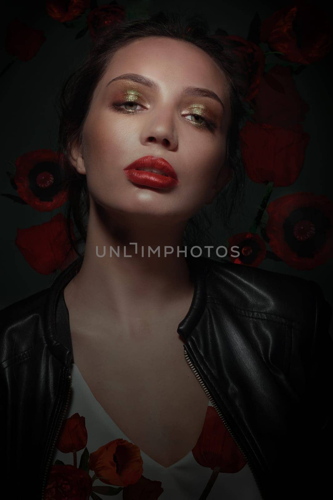 Portrait of stylish woman with poppies flowers. Professional makeup, green eyeshadow and red lips. Fashion.