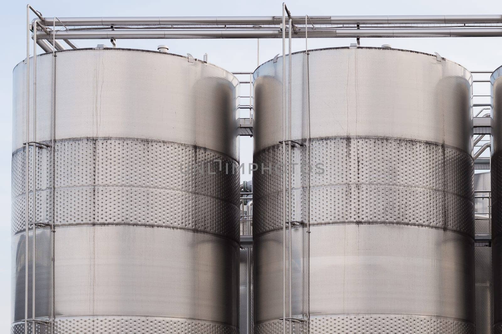 Three wine blending tanks glisten in the afternoon sun.