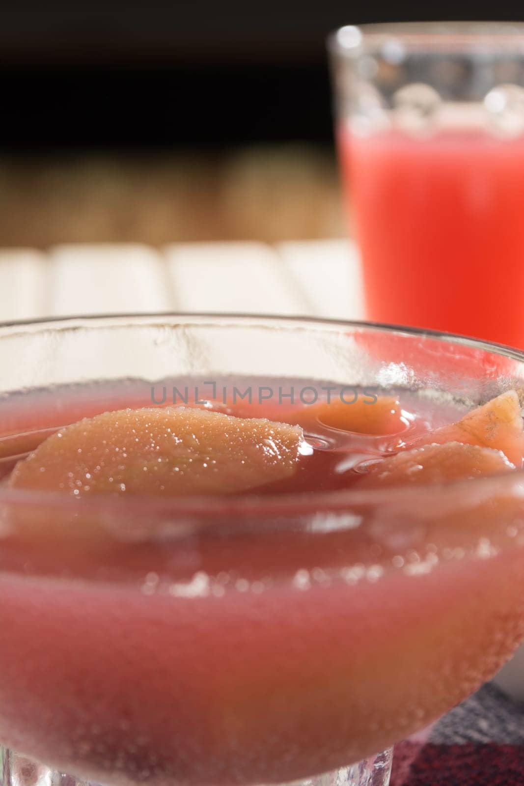 Apple compote with dried fruits in the cup on wooden table with decorative wallnuts
