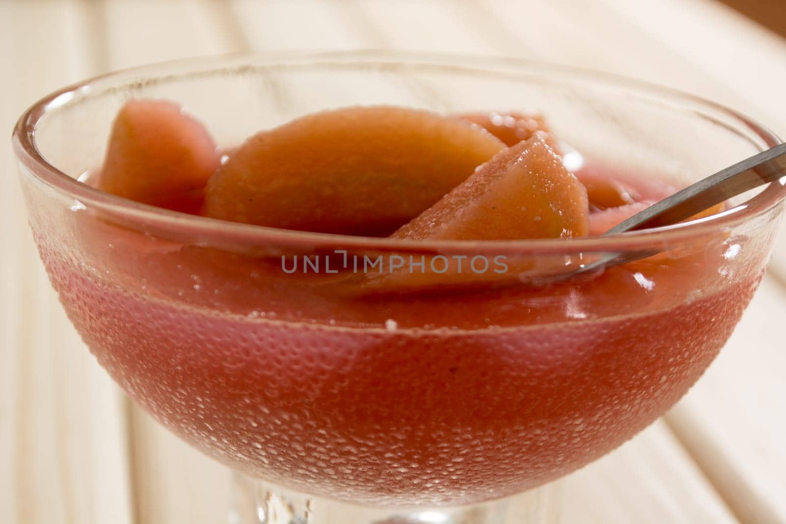 Compote of dried apple in the bowl on a wooden table
