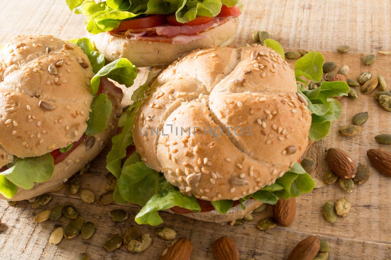 Sandwiches with fresh smoked meat, cheese, lettuce and tomato with homemade ketchup arranged with almond and pumpkin seeds