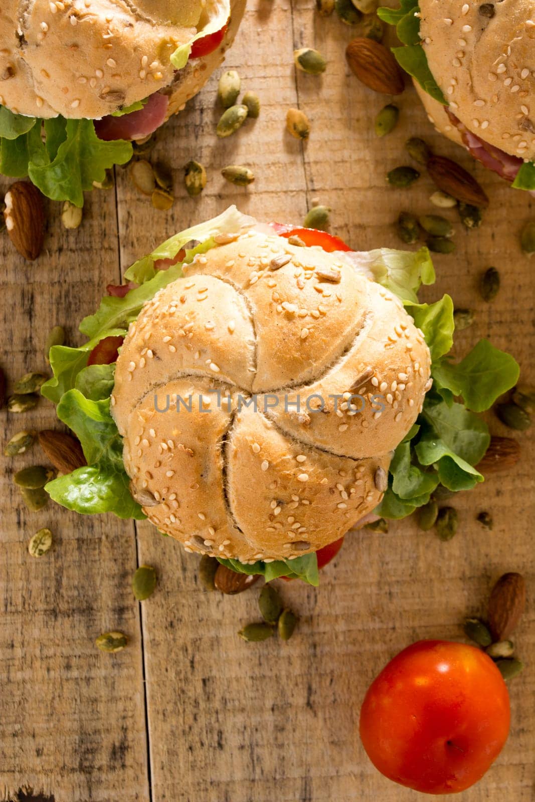 Sandwiches with fresh smoked meat, cheese, lettuce and tomato with homemade ketchup arranged with almond and pumpkin seeds