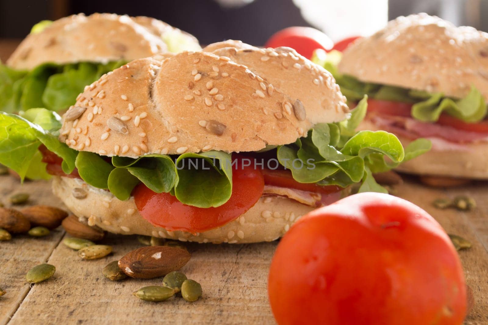 Sandwiches with fresh smoked meat, cheese, lettuce and tomato with homemade ketchup arranged with almond and pumpkin seeds