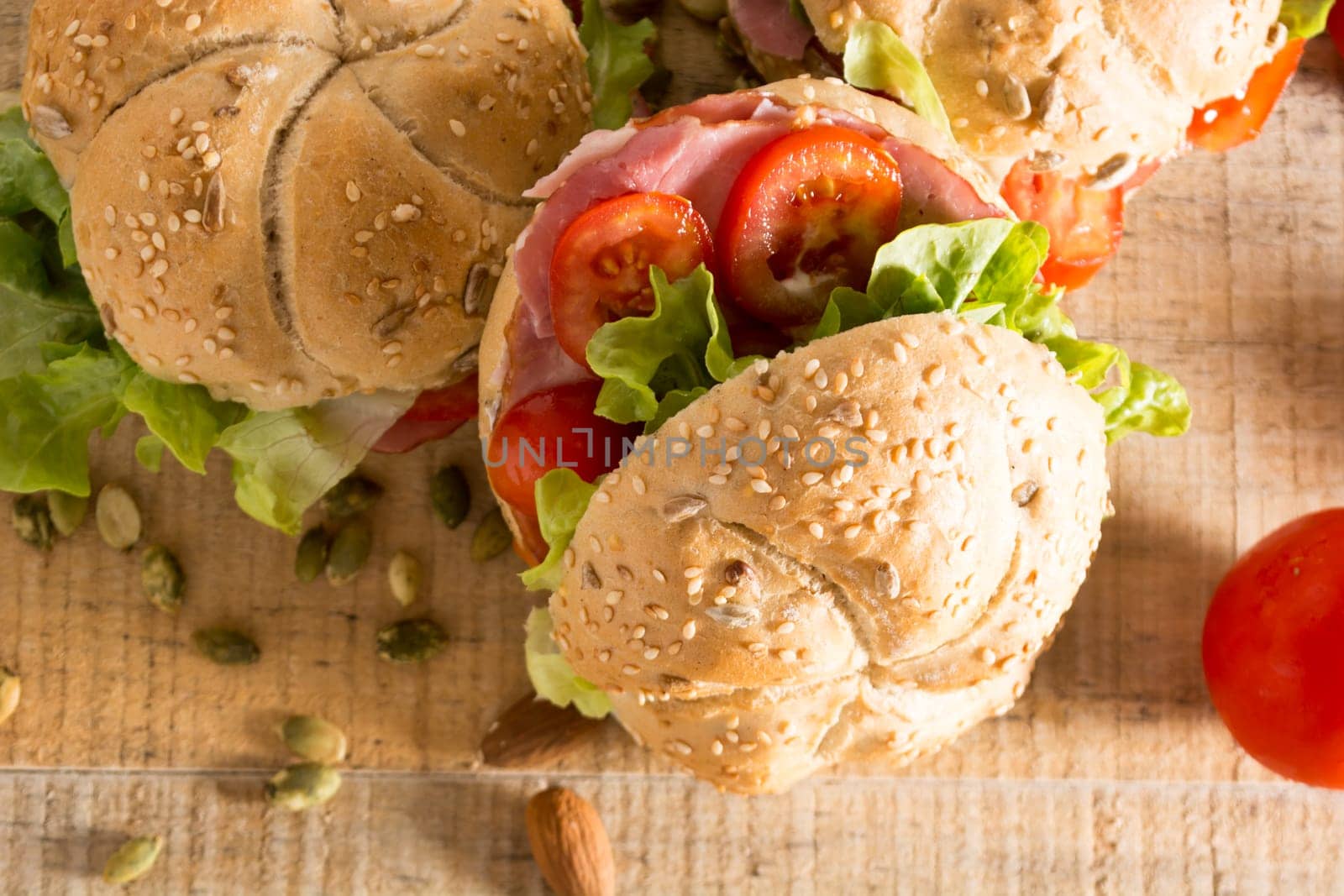 Sandwiches with fresh smoked meat, cheese, lettuce and tomato with homemade ketchup arranged with almond and pumpkin seeds