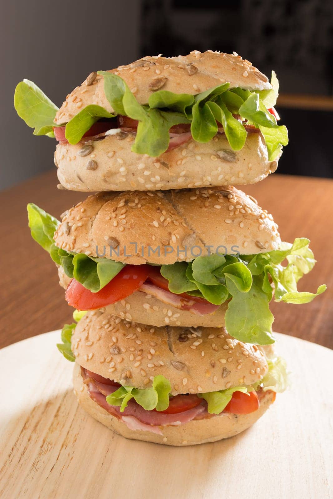 Three Sandwiches with fresh smoked meat, cheese, lettuce and tomato with homemade ketchup stacked one on another