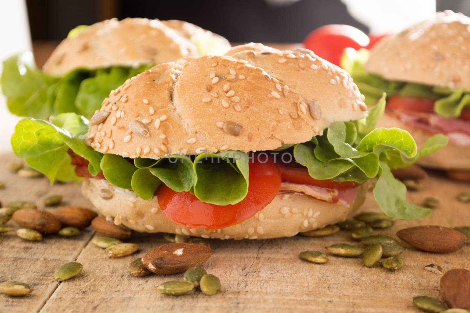 Sandwiches with fresh smoked meat, cheese, lettuce and tomato with homemade ketchup arranged with almond and pumpkin seeds