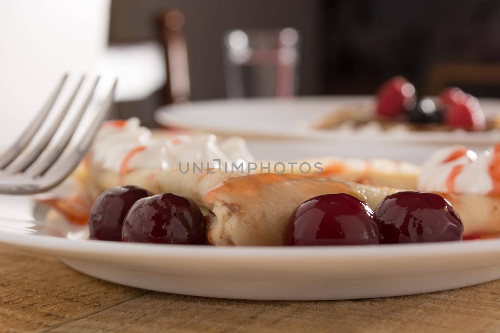 Fresh pancakes with cherry arranged on wooden table