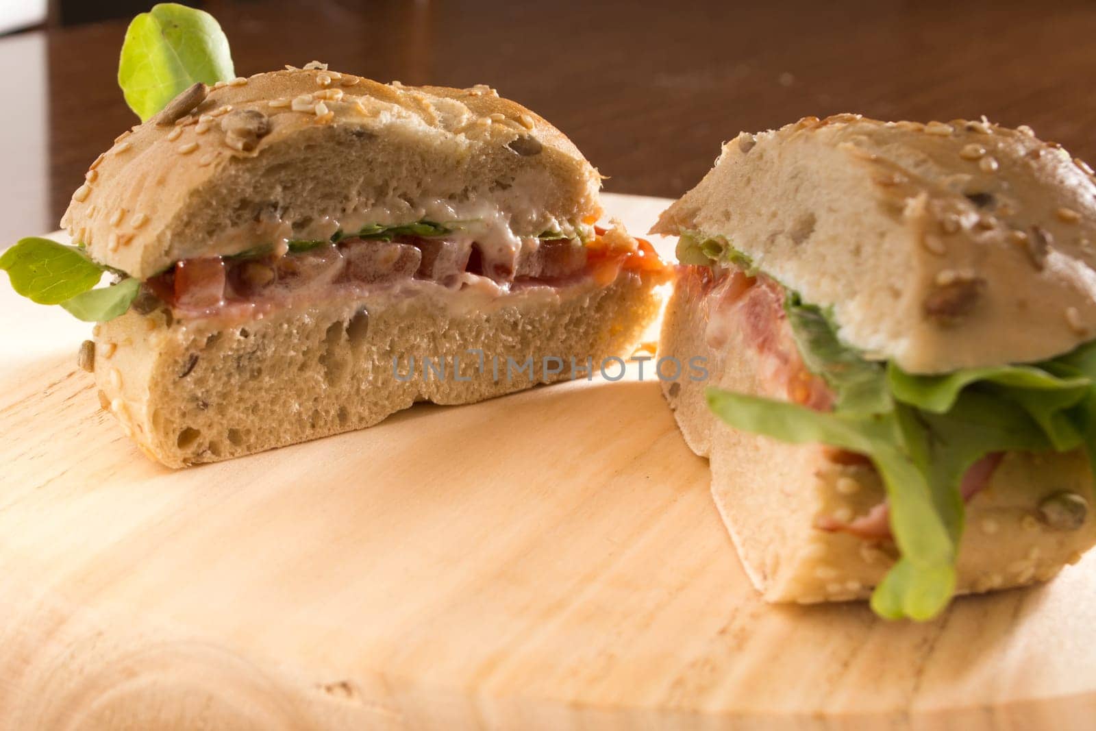 Sandwich with fresh smoked meat, cheese, lettuce and tomato with homemade ketchup sliced in half