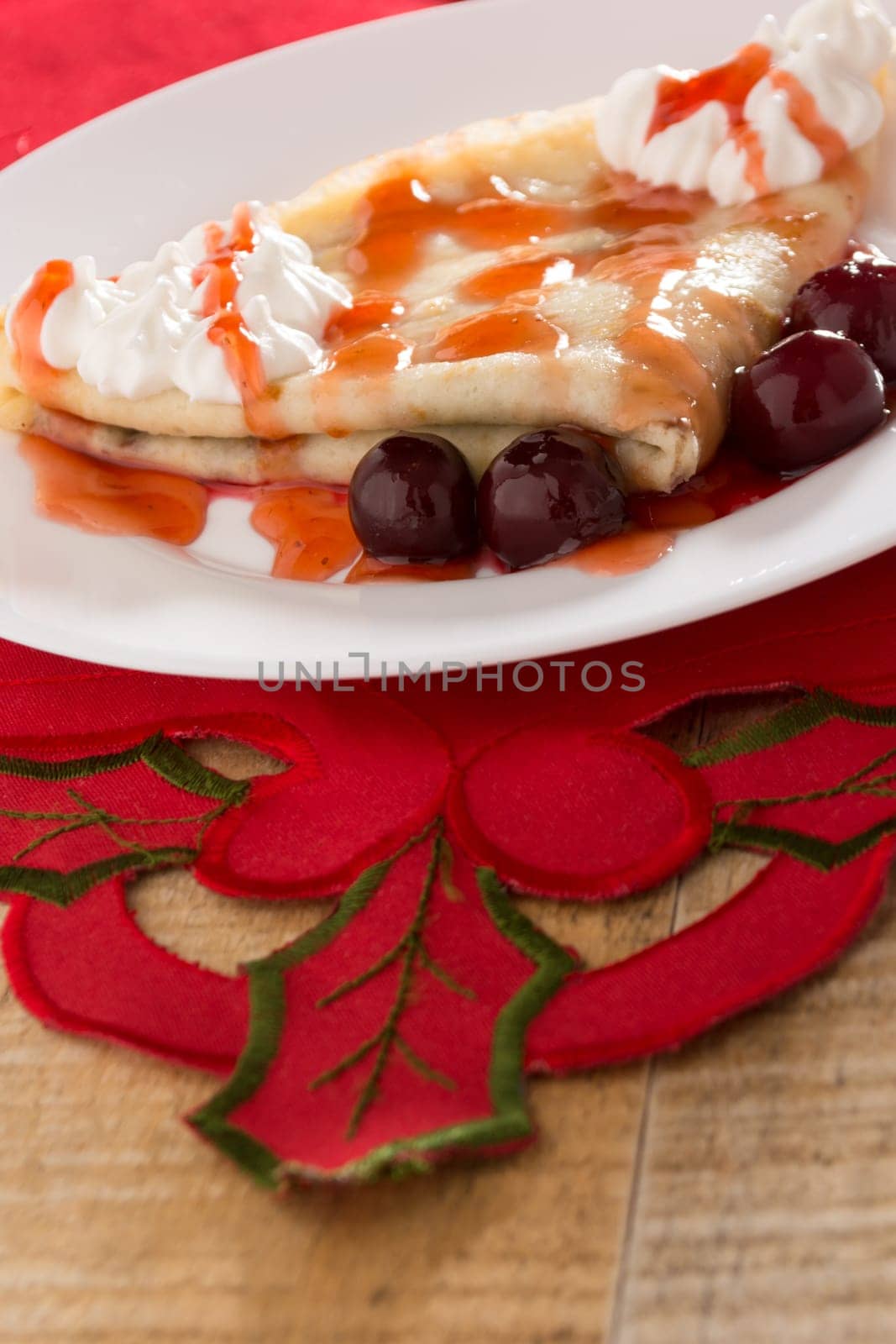 Fresh pancakes with cherry arranged on wooden table