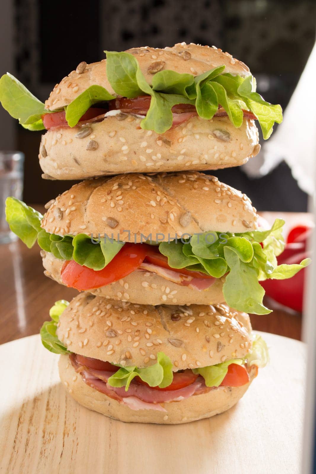 Three Sandwiches with fresh smoked meat, cheese, lettuce and tomato with homemade ketchup stacked one on another
