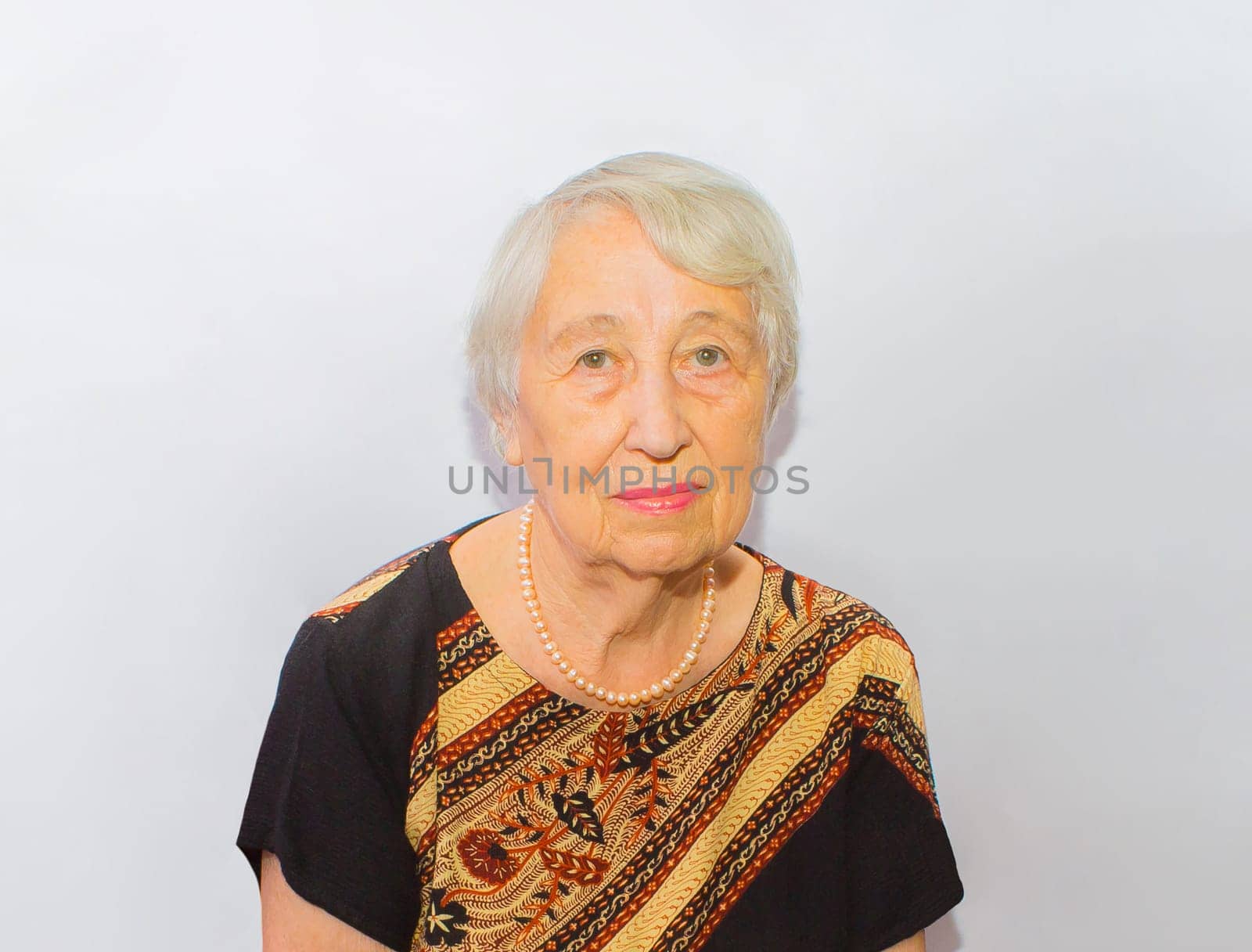 Old woman face portrait, aging process concept on gray