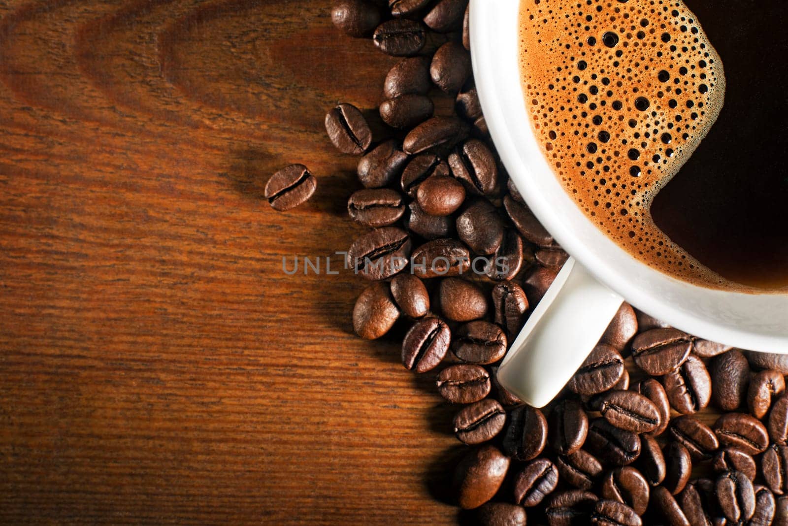 Coffee cup and beans on a wooden background.