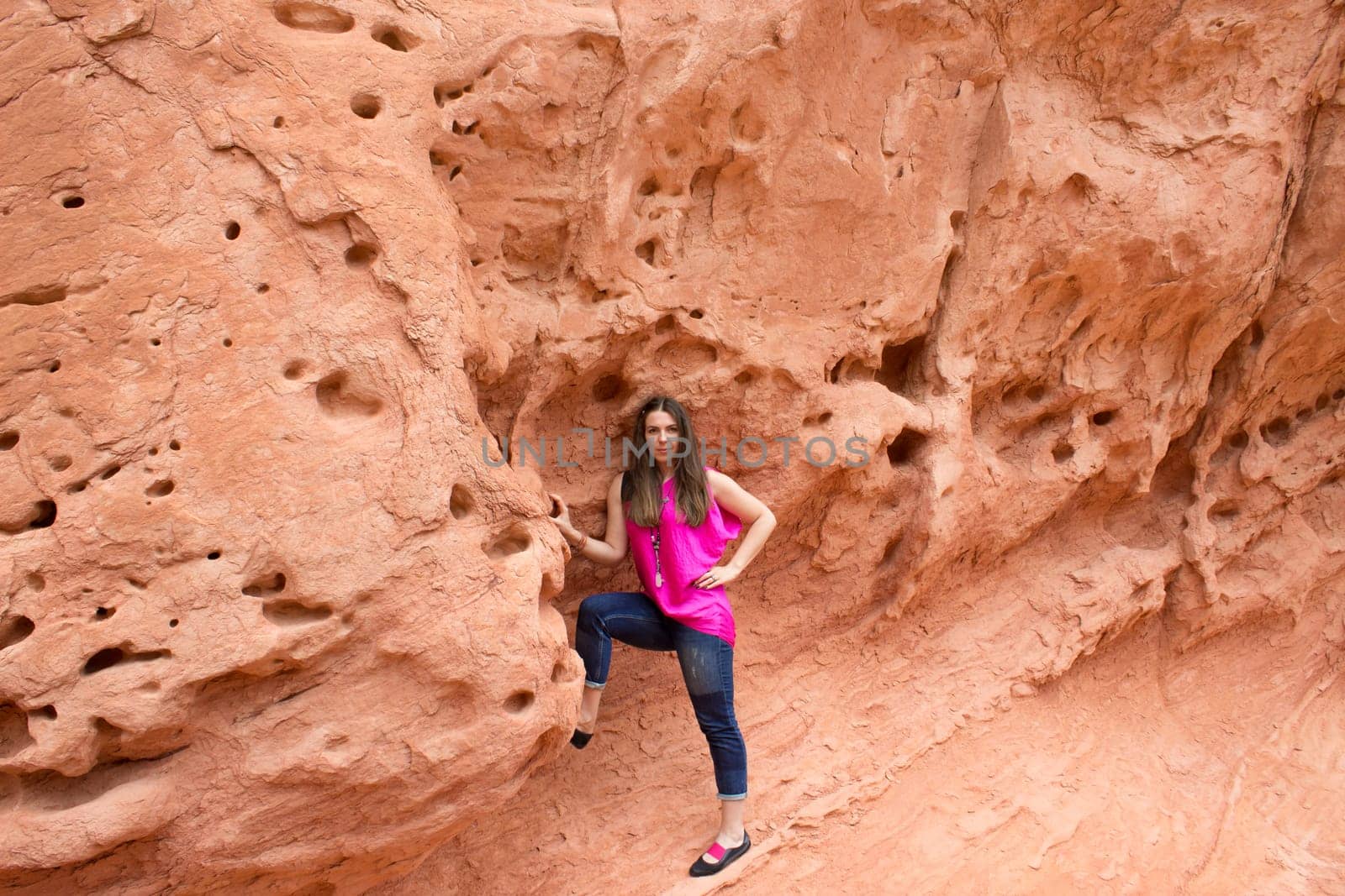 The young woman posing at Valley of Fire State Park, USA. The Valley of Fire State Park is the oldest state park in Nevada, USA and was designated as a National Natural Landmark in 1968.