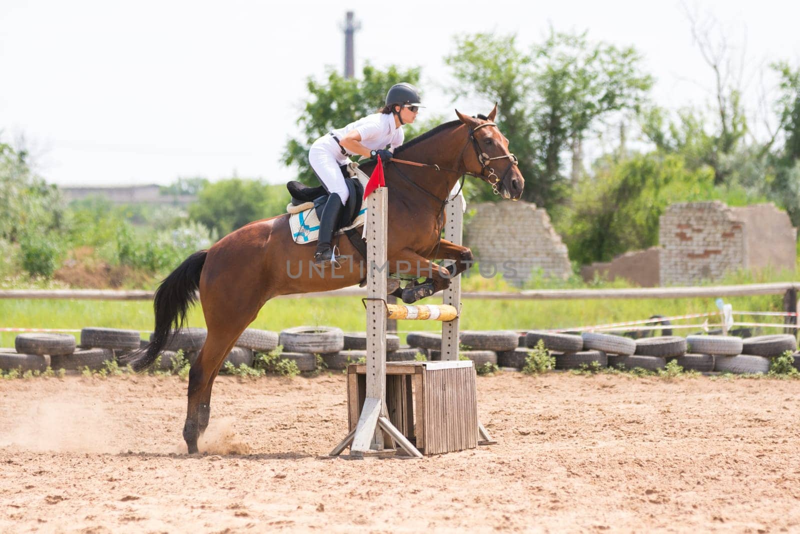 Volgograd, Russia - June 19, 2016: sportsman on horse jumping over a hurdle in the jumping competition, the moment of separation from the earth