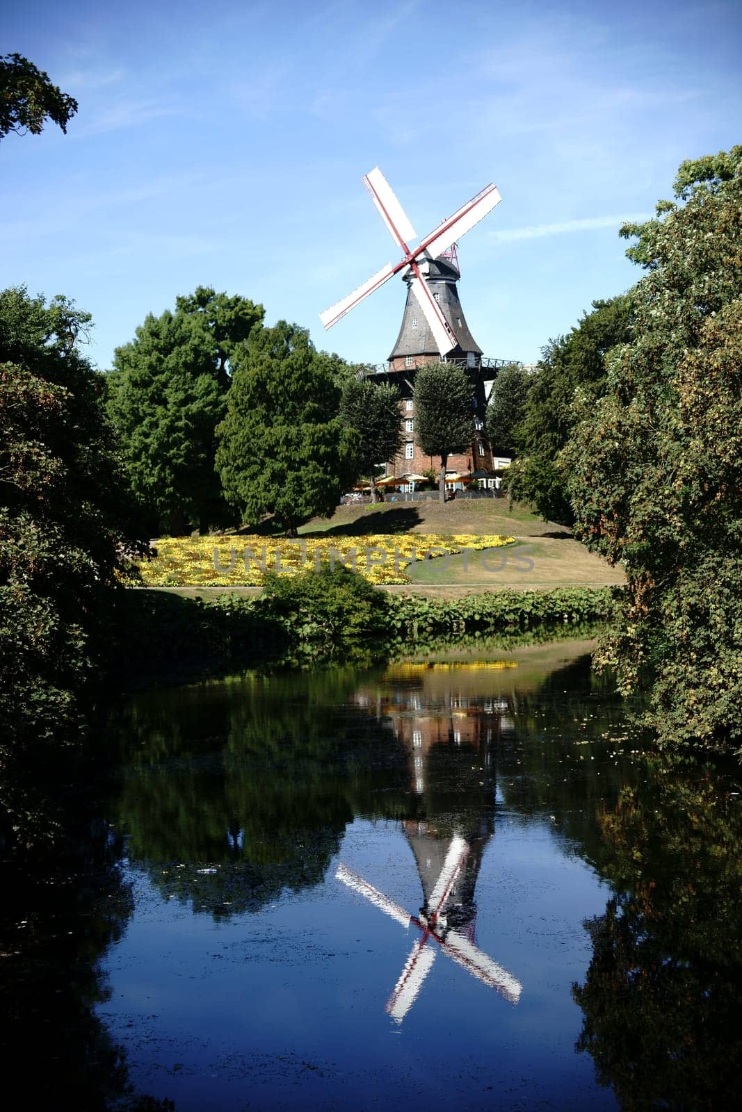 The Herdentorswallmühle or Mühle am Wall with flower beds behind a pond.