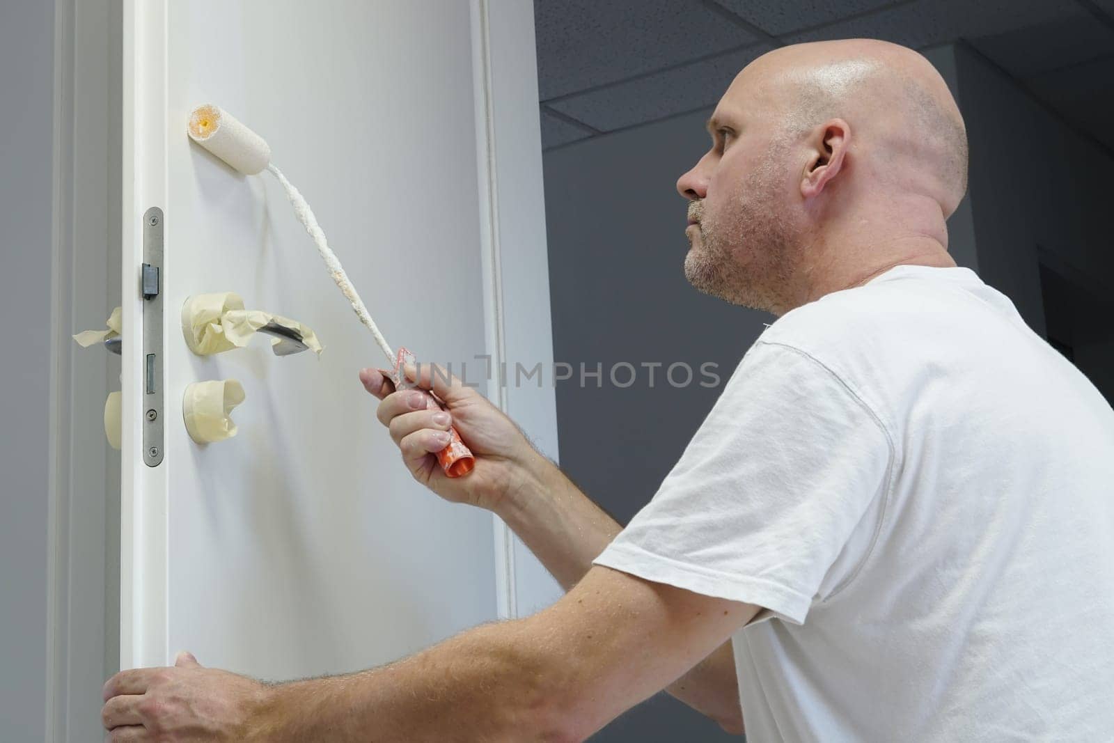 Craftsmen painting a door in an office building