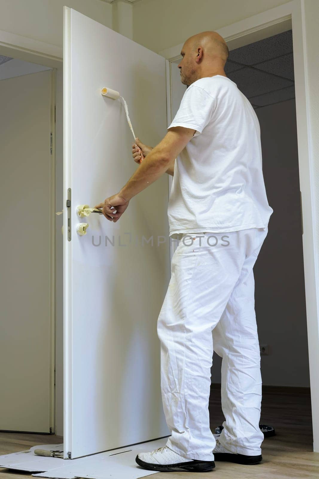 Craftsmen painting a door in an office building