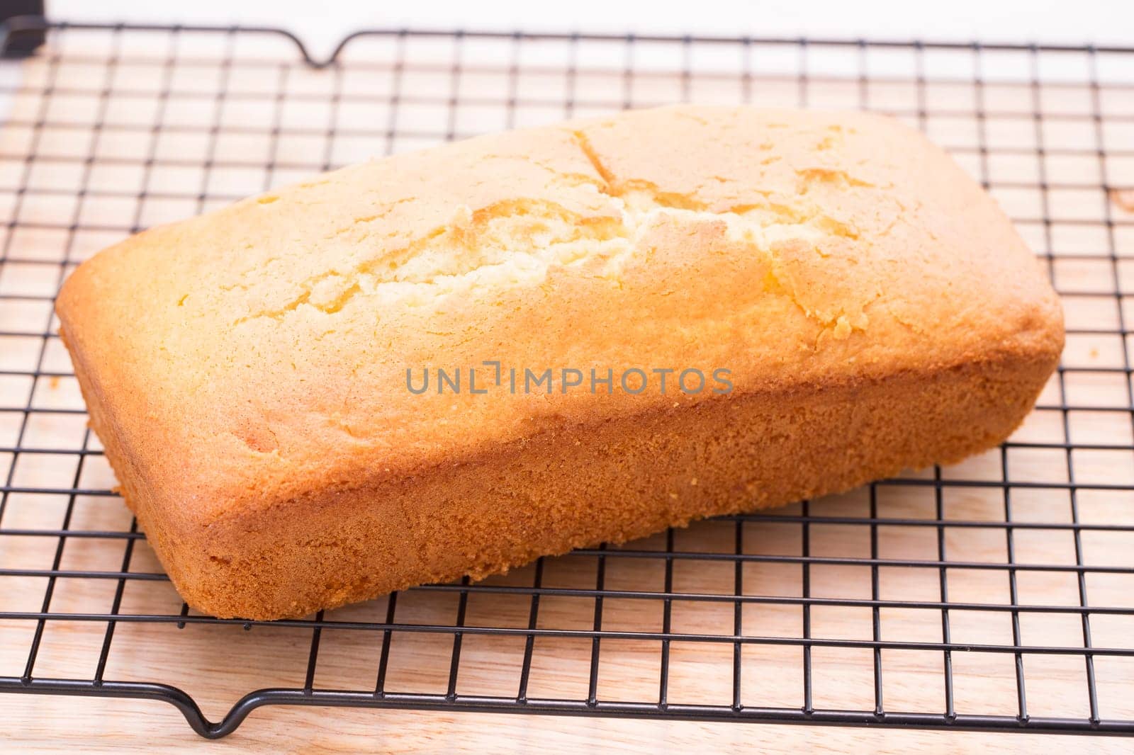 Lemon pound cake loaf cooling on rack.