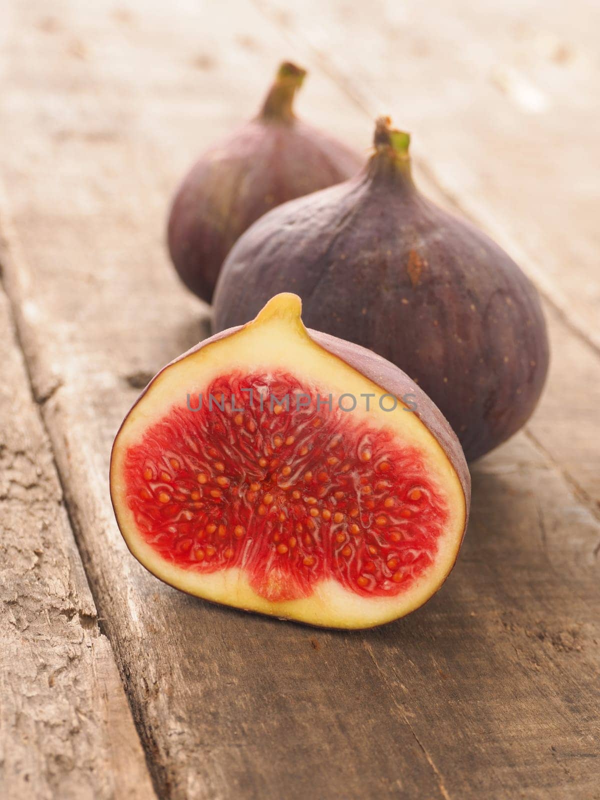Fresh organic figs on a rustic wooden table in a kitchen