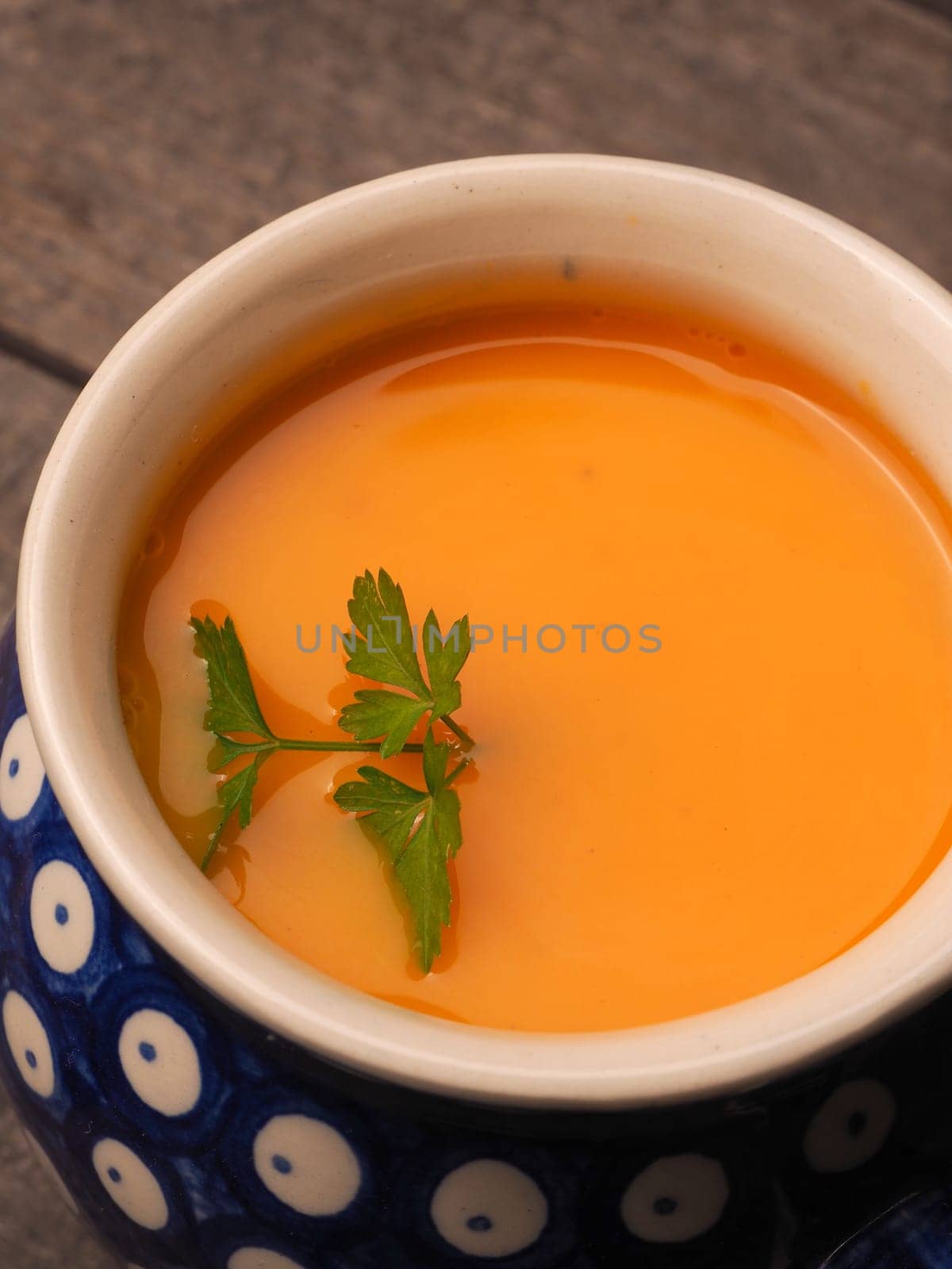 Closeup of a pumpkin cream soup in a rustic bowl