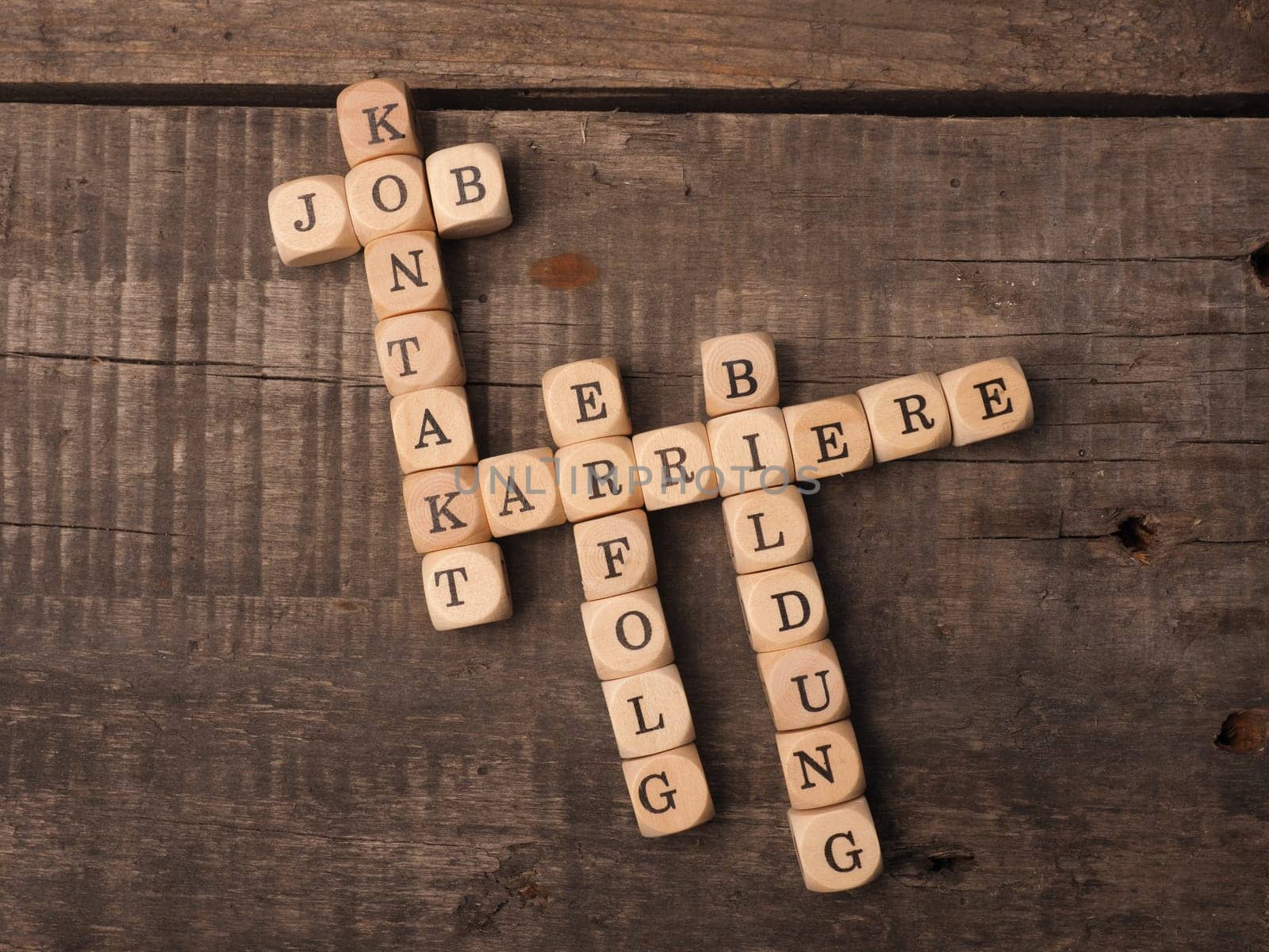 German career concept with the crosswords career, education, job, success and contact on a rustic wooden table