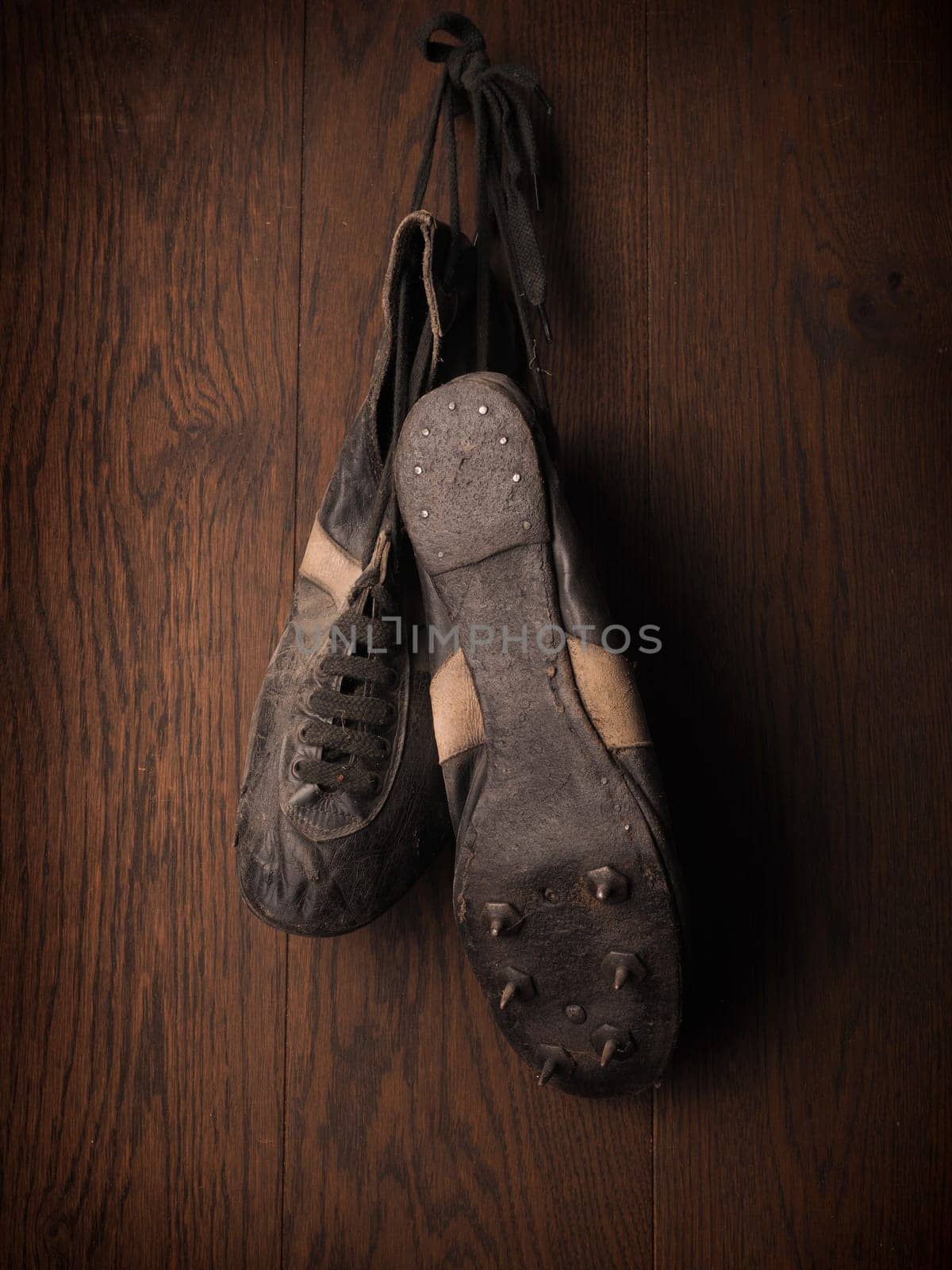 Old sports shoes from 1930 on a rustic wooden wall