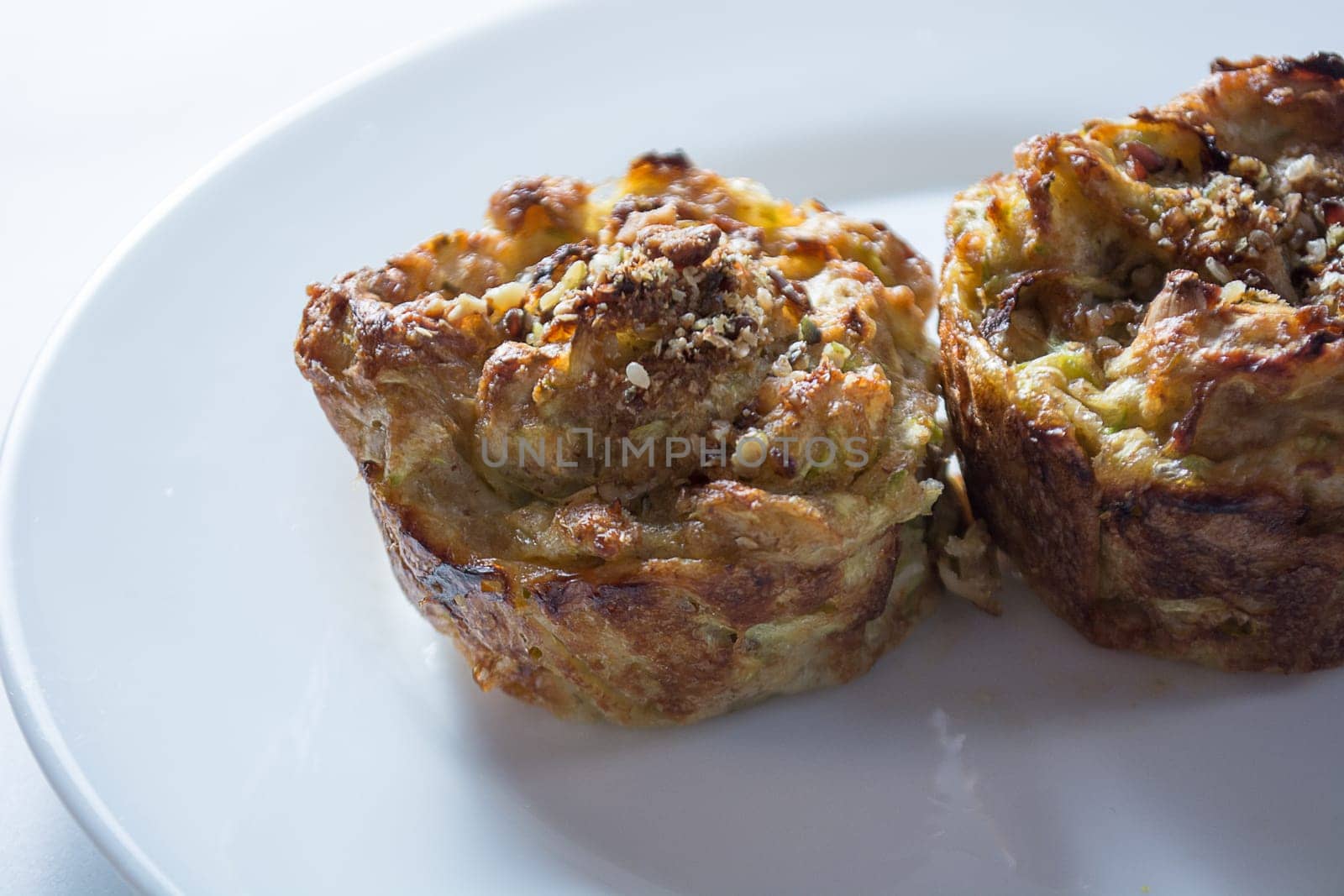 Zucchini muffins in white plate isolated on white background