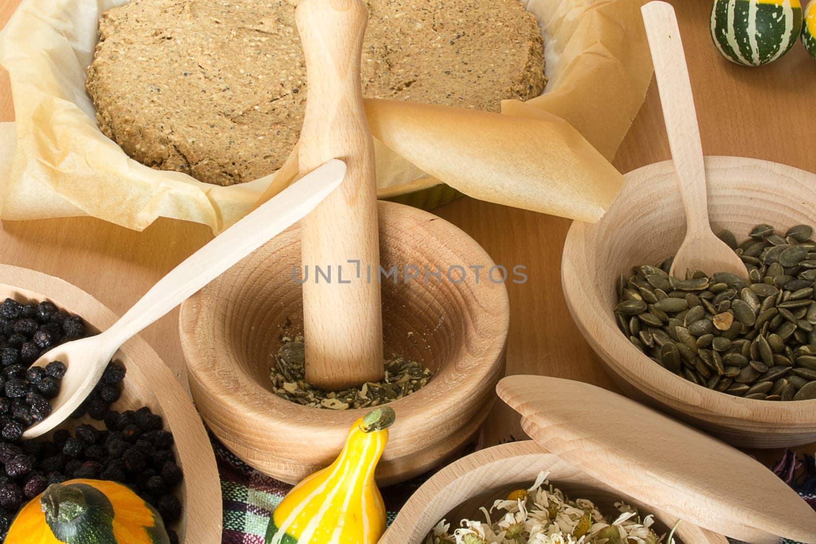 Various seeds and berries in wooden kitchen wares placed on kitchen table