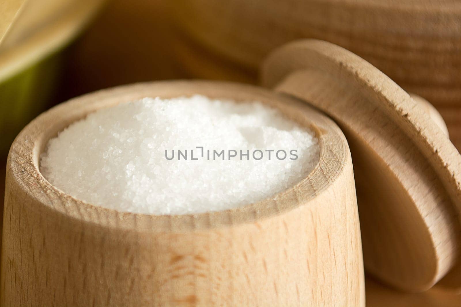 Close up of small wooden cup full of salt sitting on the kitchen table