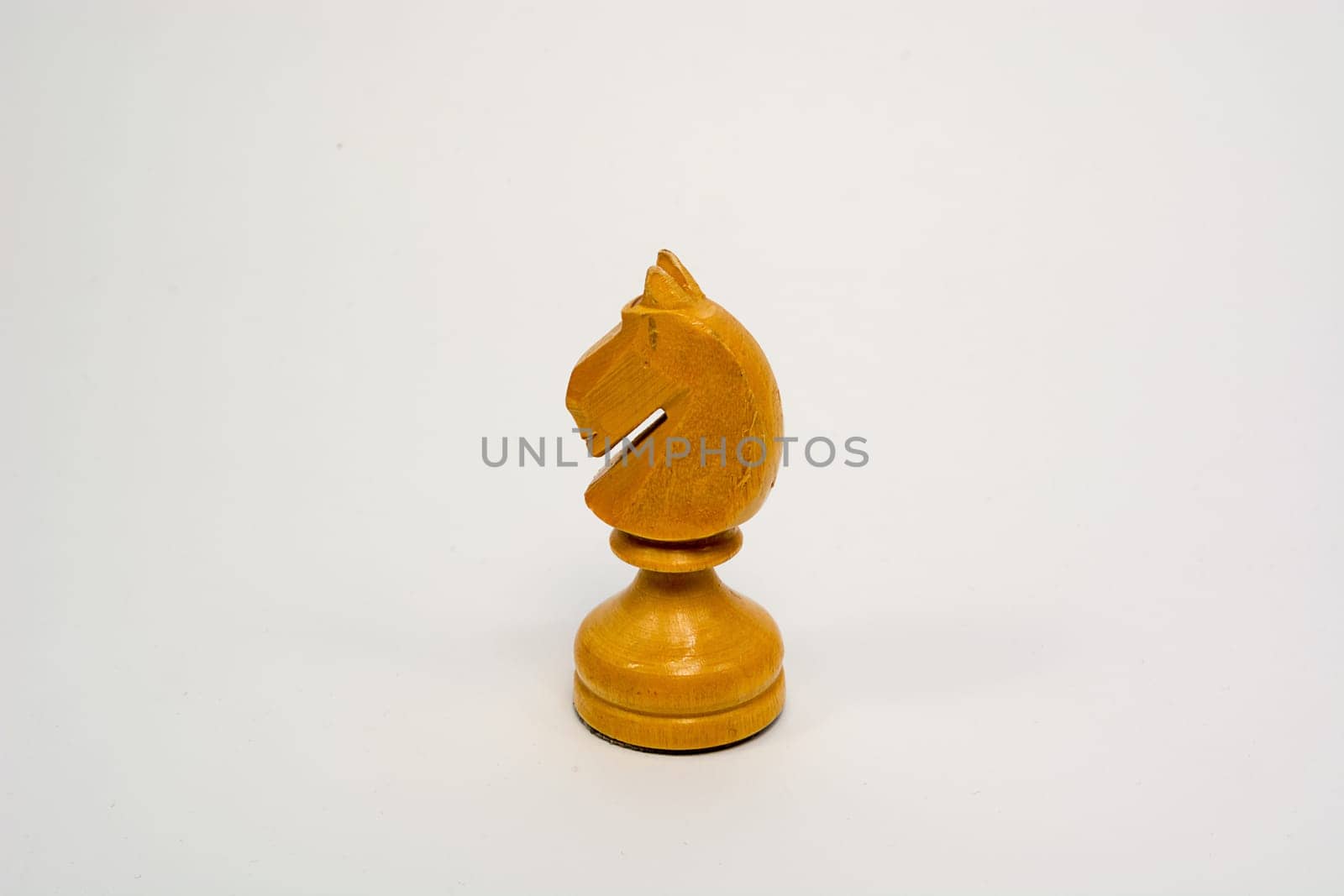 Old wooden chess piece white knight isolated on white background