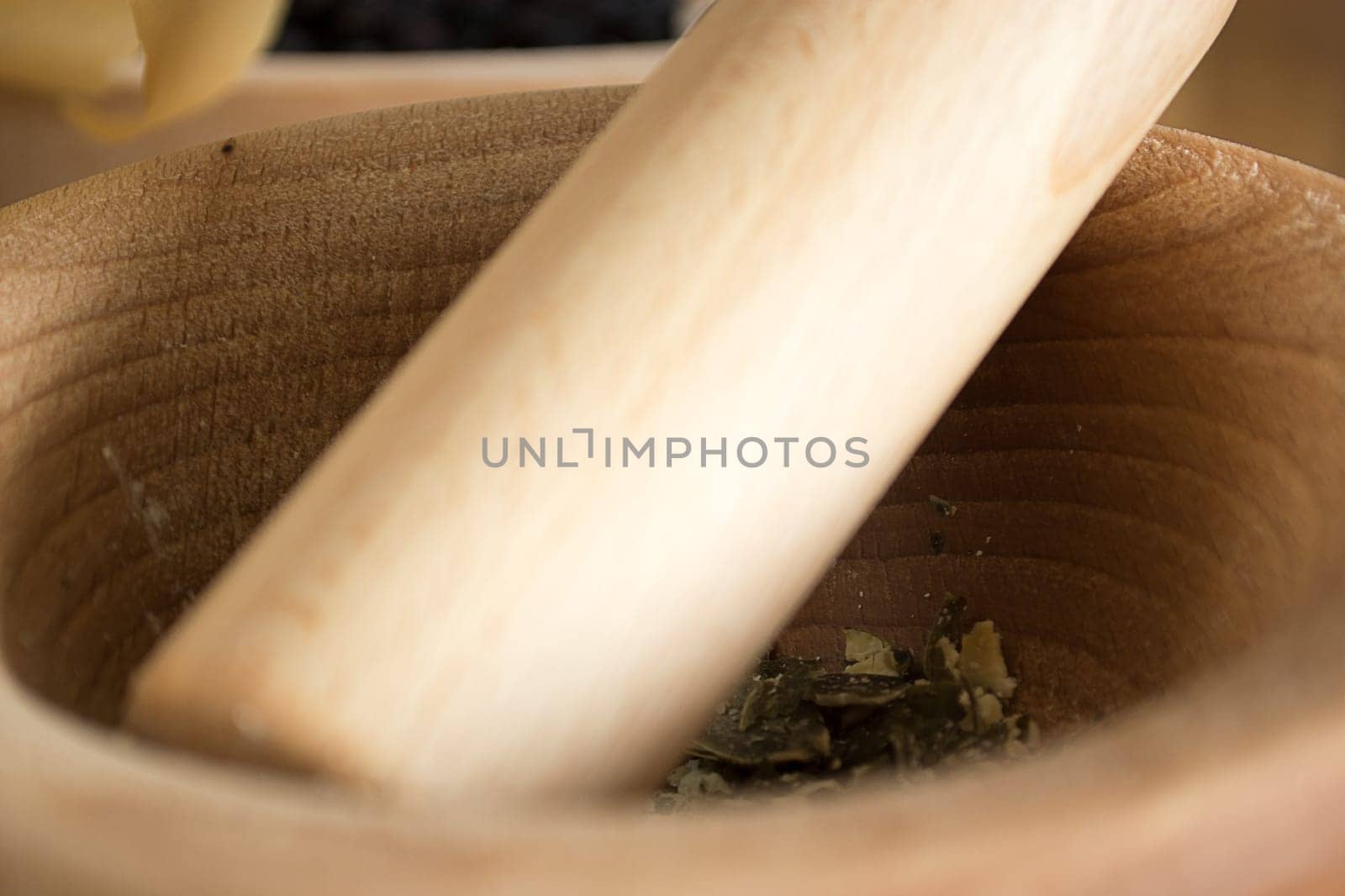 wooden mortar on wooden kitchen table with cracked pumpkin seeds