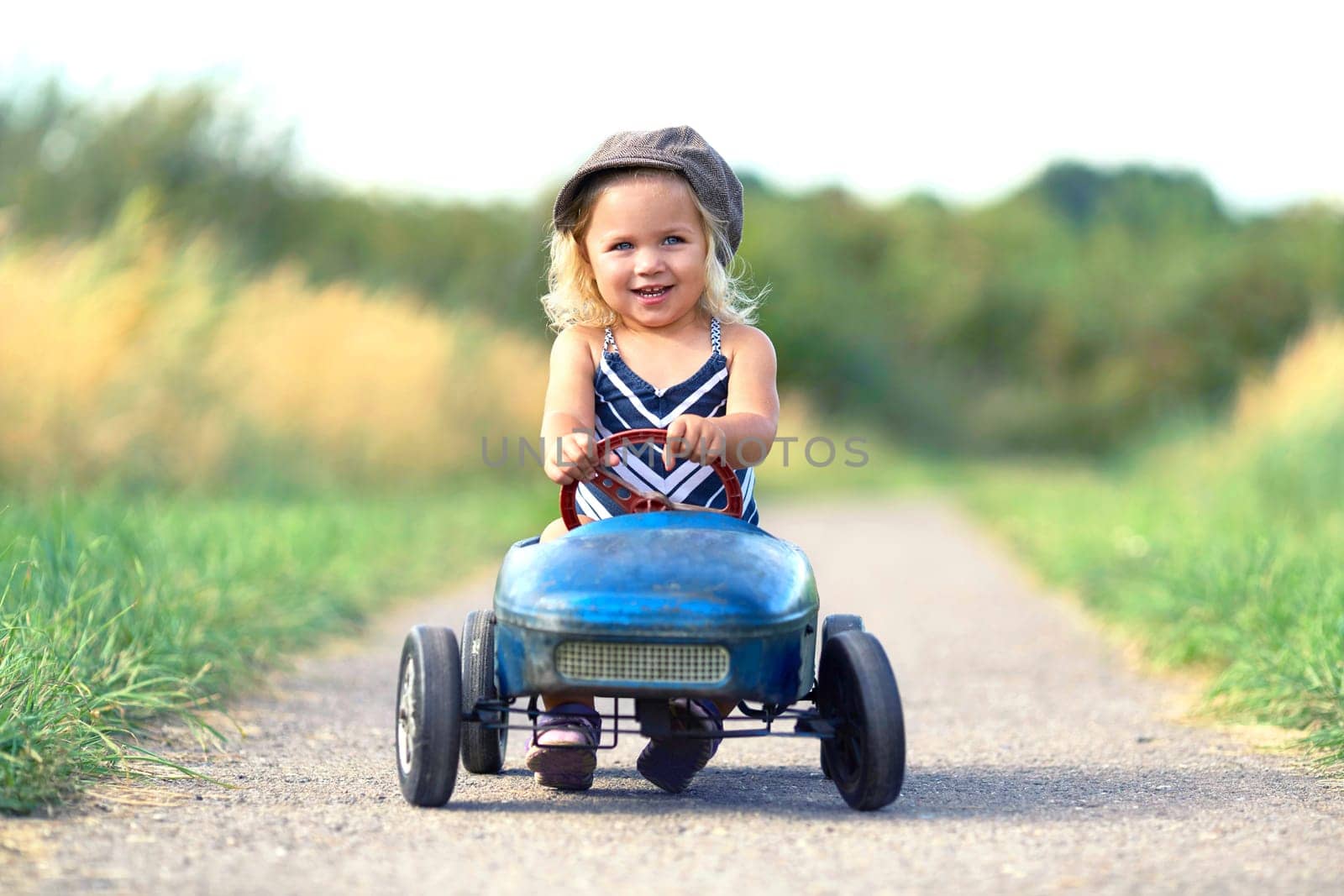 laughing little girl with nostalgic pedal car