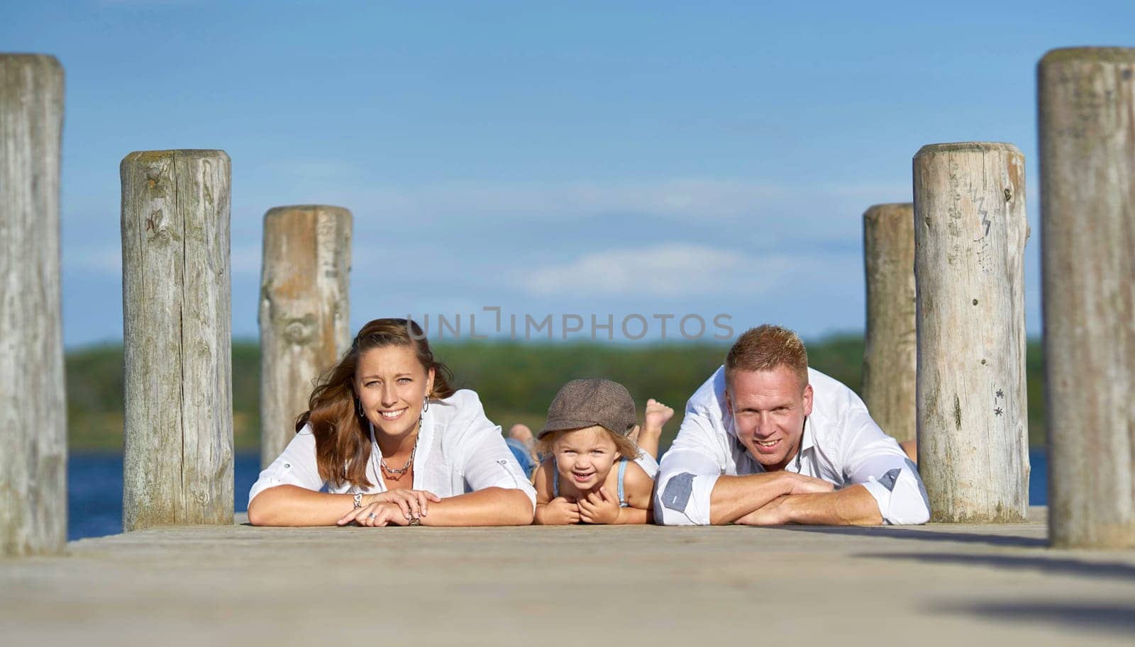 happy young family at the jetty on the lake