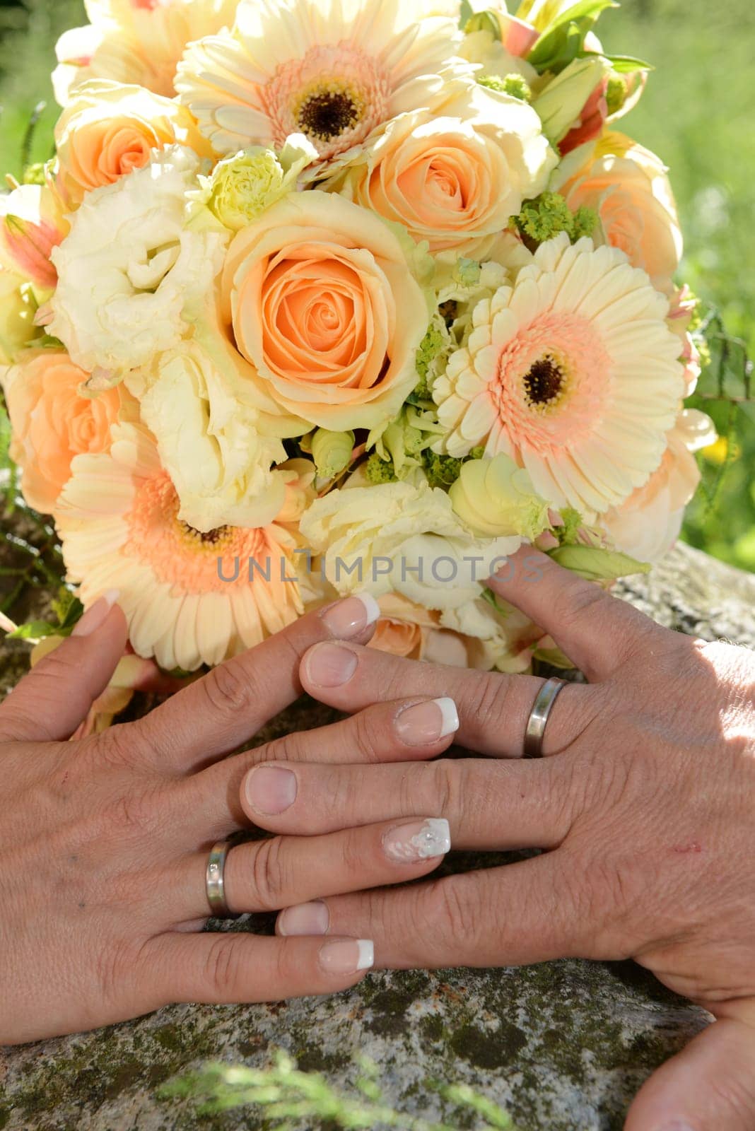 Bridal bouquet with hands from the bridal couple & wedding rings