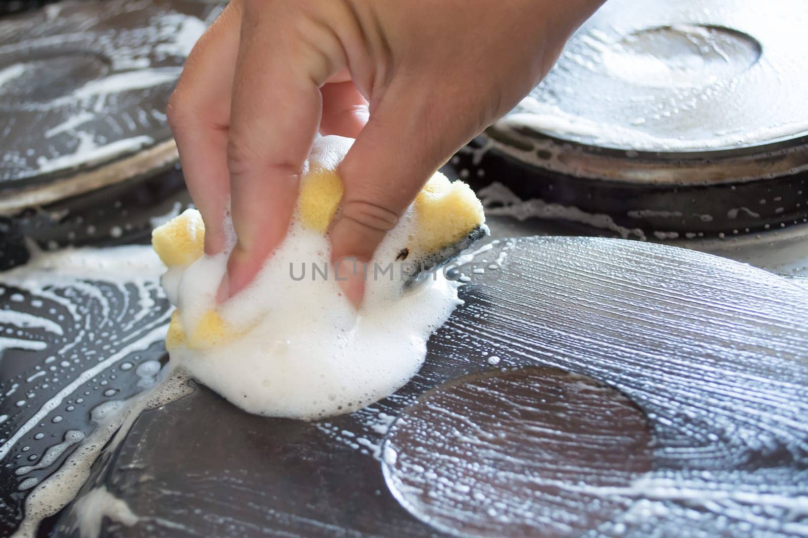 Close up of woman cleaning cooker at home kitchen