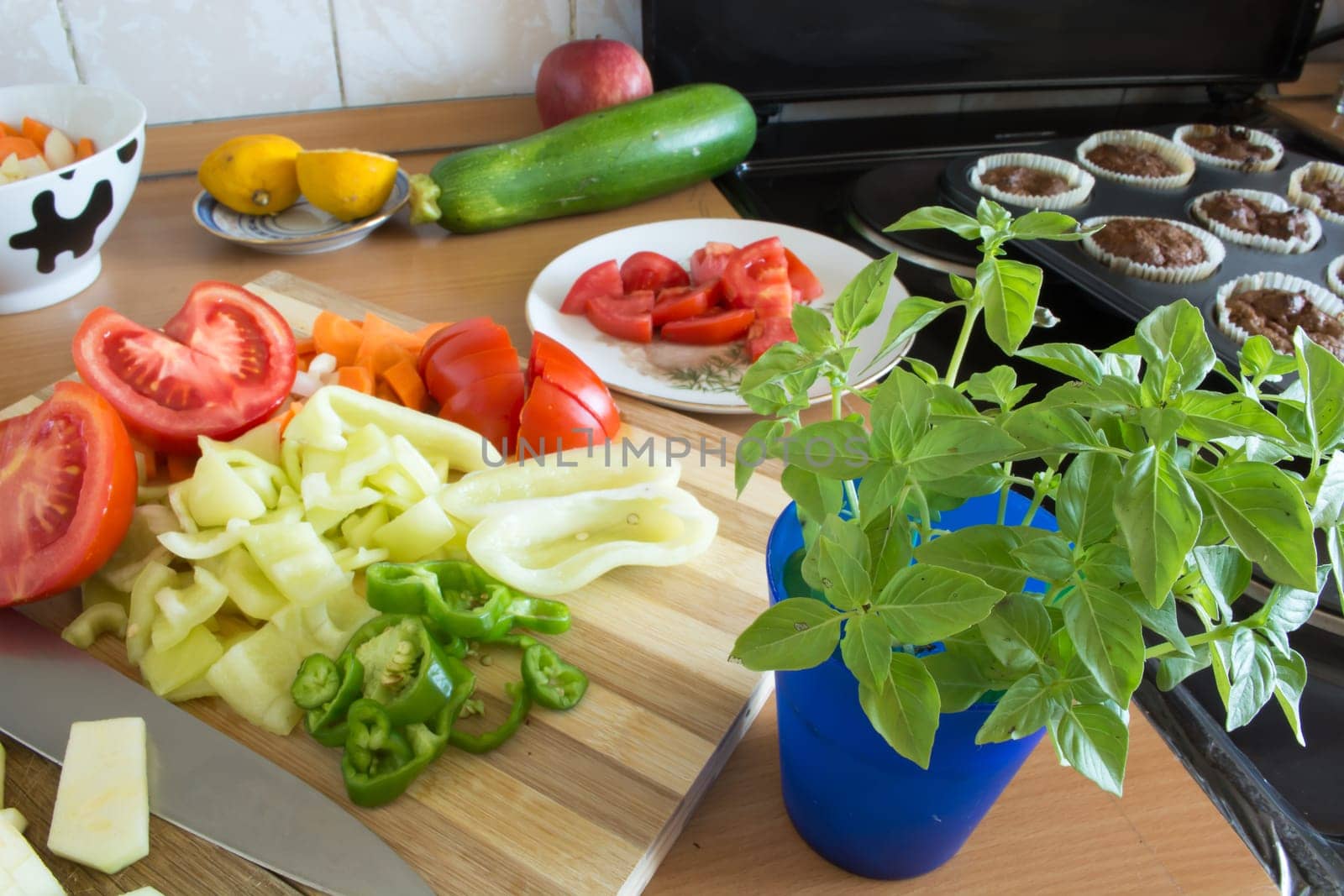 Kitchen full of various vegetables. Pepper, tomatoes sliced and ready to be boiled