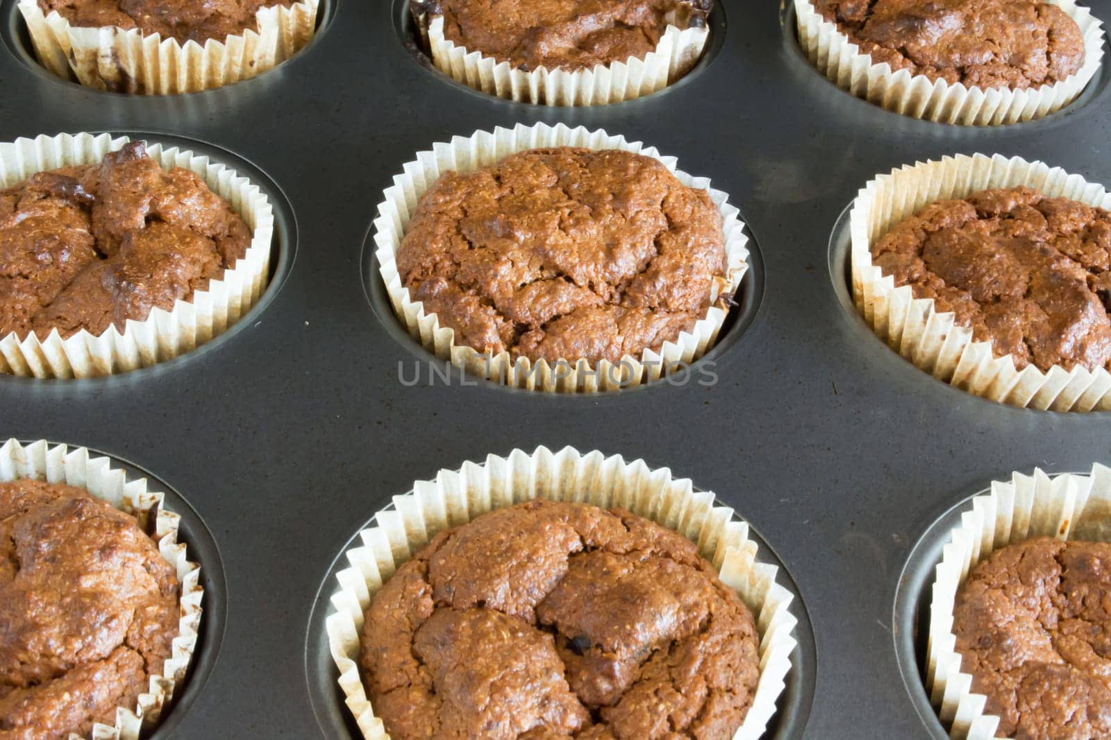 Just baked sweet chocolate cupcakes still in bake tray.