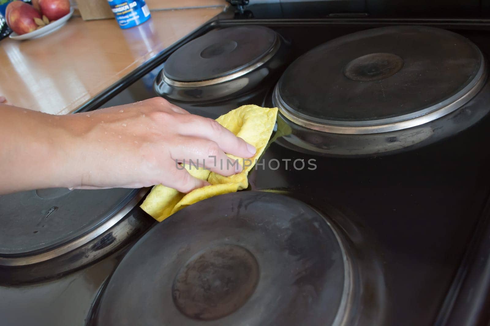 Close up of woman cleaning cooker at home kitchen