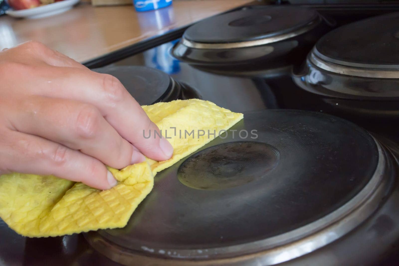 Close up of woman cleaning cooker at home kitchen