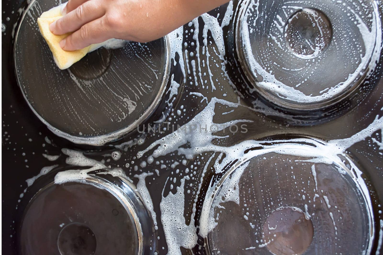 Close up of woman cleaning cooker at home kitchen