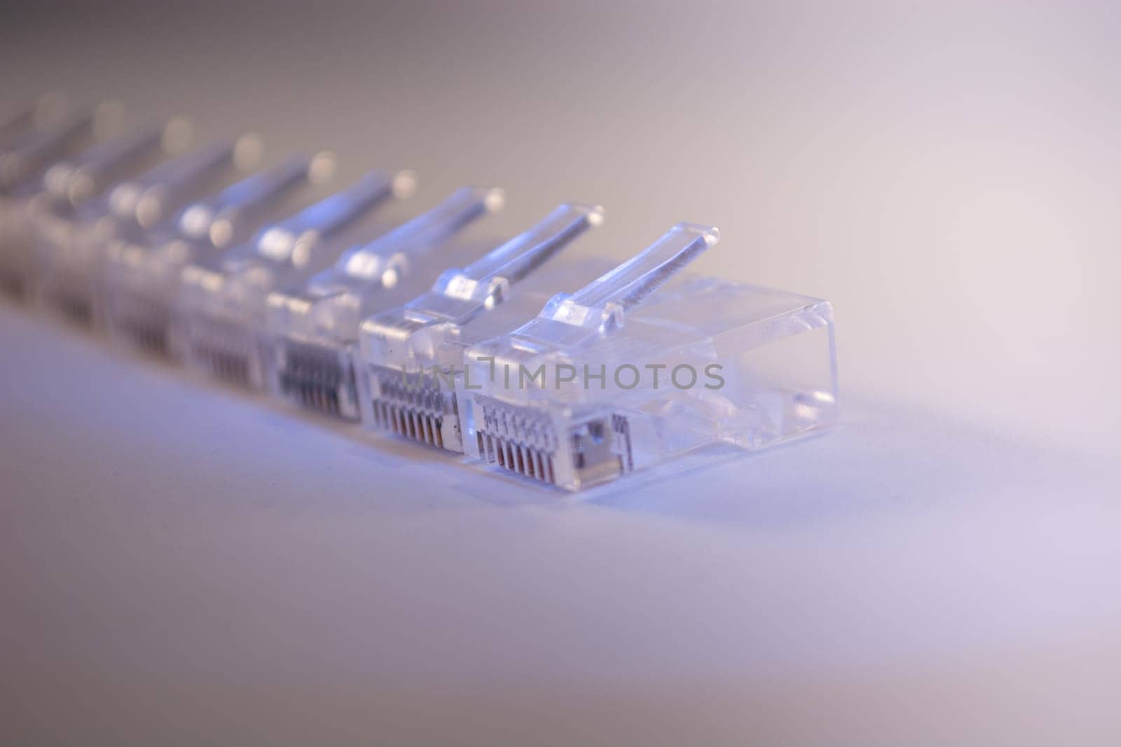 Group of RJ-45 connectors on white background, Connectors are translucent and collored with blue light